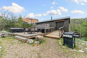 A deck with outdoor furniture, a grill, and a covered area with a table and chairs. - Hot Tub, Fire Pit, Pet Friendly Close to Lake (Eureka Springs)