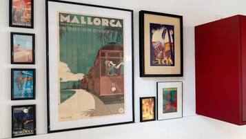 A wall with framed travel posters, including one for Mallorca and another for Brooklyn.