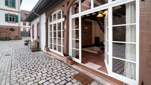 A building with large windows, a cobblestone courtyard, and a stone facade.