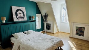 A bedroom with a bed, a teal accent wall, a window, and a radiator. - Le gite de Fontiville near the Loire castles (6 to 8 people) (Veigné)
