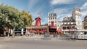 A street scene with a prominent red windmill, a café named 'OULIN ROUGE', and a tram. - Suite Prestige in Pigalle (Paris)