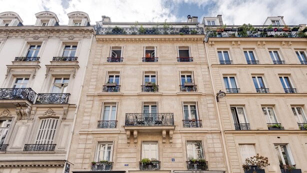 A multi-story building with ornate balconies and a classic architectural style. - Suite Prestige in Pigalle (Paris)