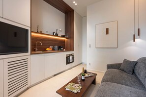 A modern kitchen with a built-in TV, wooden accents, and a dining area with a sofa and table. - Luxury design studio in Paris (Paris)