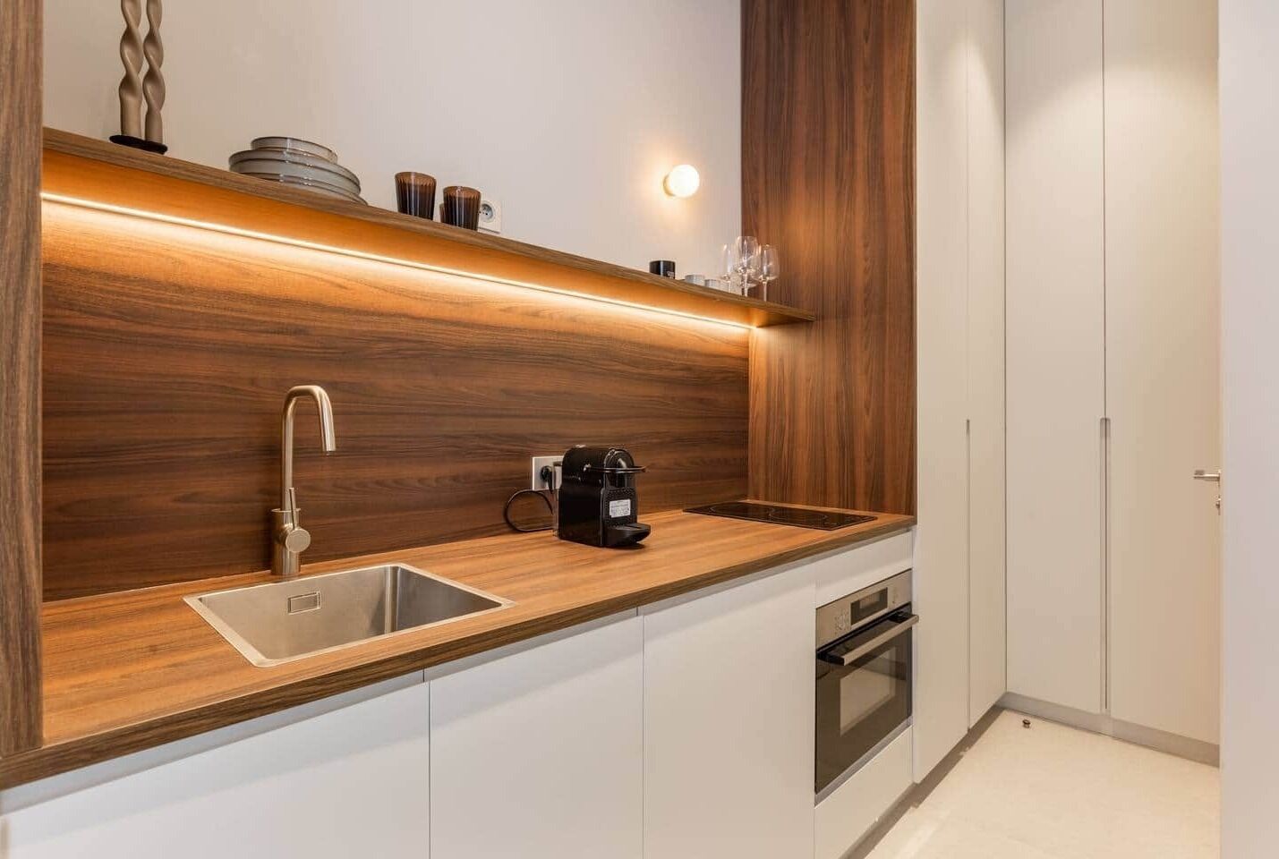 Een koelkast, een oven, een broodrooster, kookgerei, borden en bestek