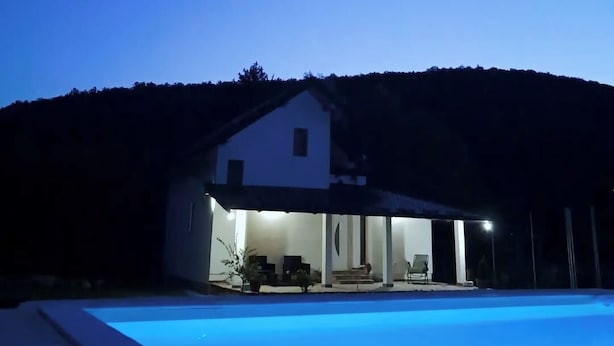 Una casa moderna con piscina al atardecer.
