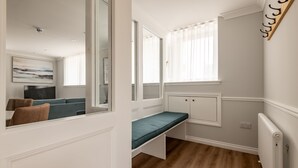 A modern room with a built-in bench, large windows, and a view of the outside. - Skye Sands | St Mary’s Gardens (No 2) (St Andrews)