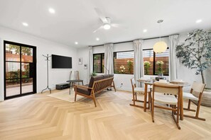 
An open and inviting living space with stylish seating and a dining area, perfect for relaxing or enjoying a meal together. - La Jolla Luxury 2BR | Tesla Charger + Parking (San Diego)