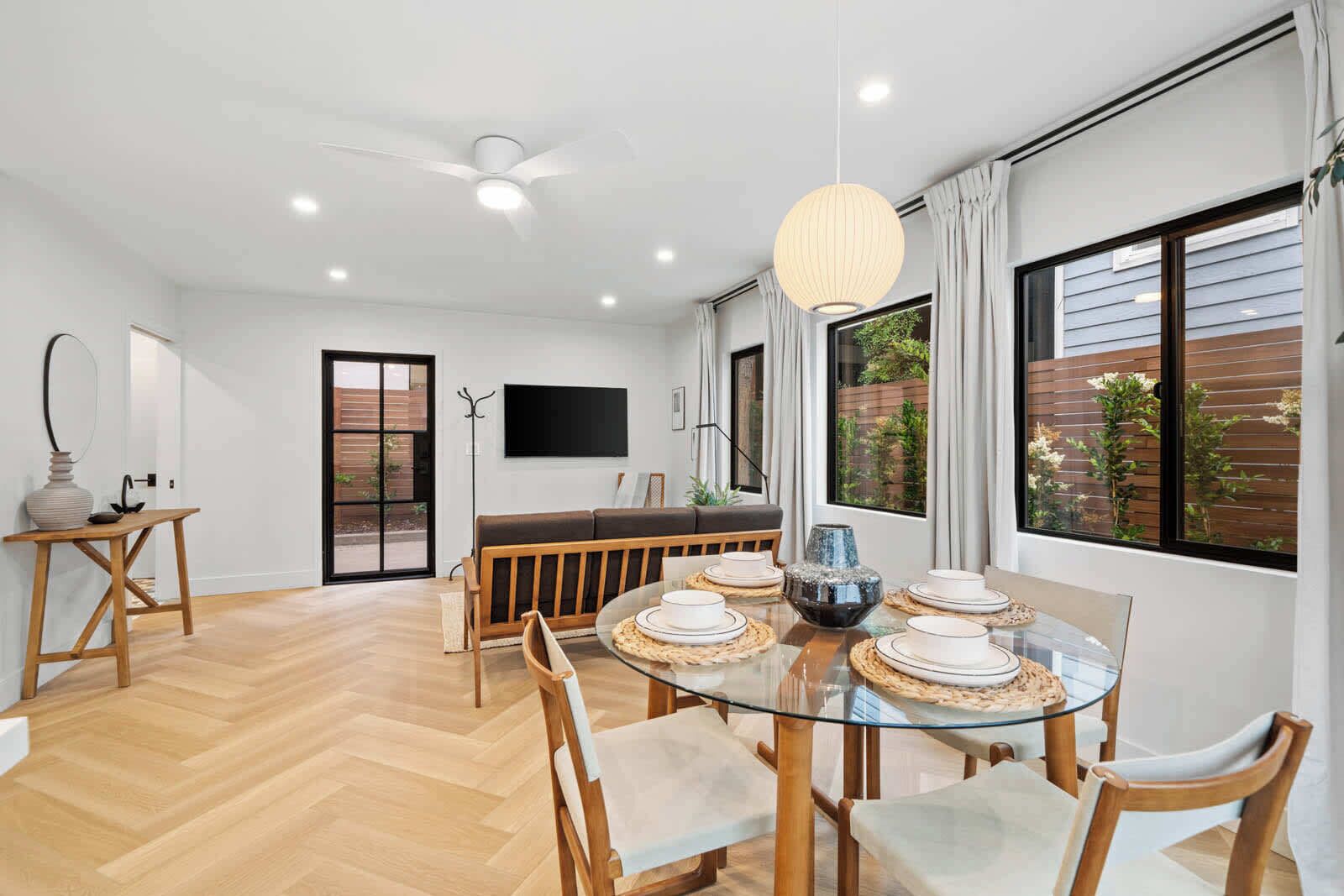 
Spacious, light-filled living area with an inviting dining table. Relax on the comfortable couch and enjoy a movie night on the large flat-screen TV.