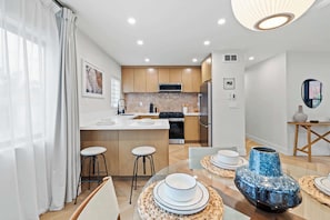 Sleek, modern kitchen with all the essentials. Enjoy a quick meal at the breakfast bar or a leisurely dinner at the stylish dining table. - La Jolla Luxury 2BR | Tesla Charger + Parking (San Diego)