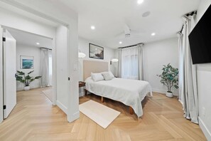 Step into this tranquil primary bedroom, a serene retreat designed for ultimate relaxation. The room features a comfortable bed and is filled with natural light. - La Jolla Luxury 2BR | Tesla Charger + Parking (San Diego)