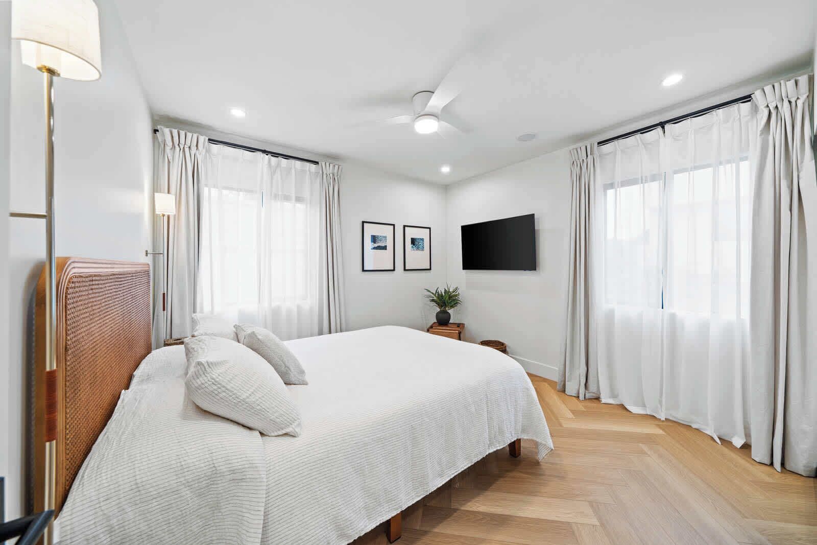 Unwind in the primary bedroom. This spacious retreat features a queen-size bed, a smart TV, and ample natural light for a relaxing and peaceful stay.