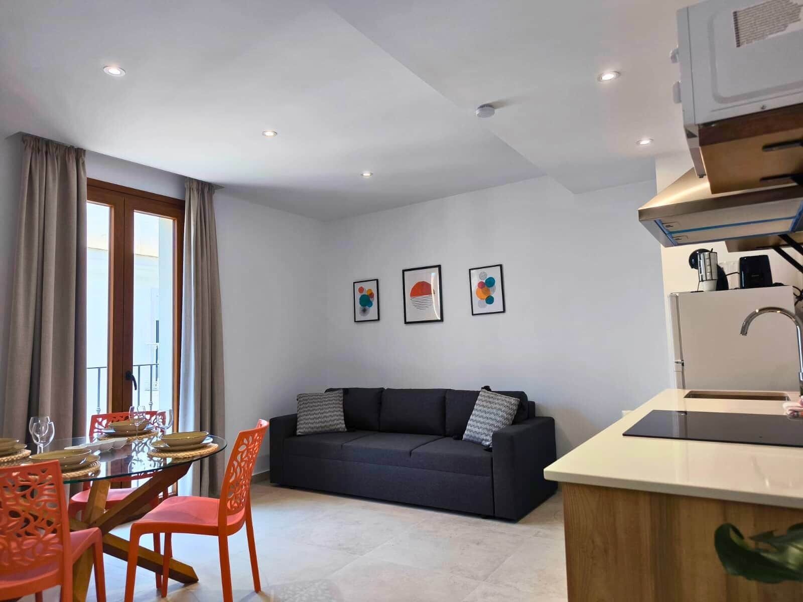 Un espacio moderno para vivir con comedor, sofá y kitchenette.