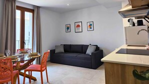 Un espace de vie moderne comprenant un coin repas, un canapé et une kitchenette.