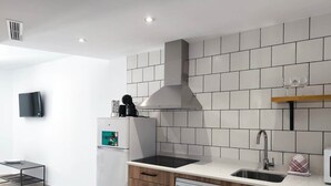 A modern kitchen with white tiles, a built-in oven, a dishwasher, and a sink. - Pepa · Serenity Apartment (Nerja)