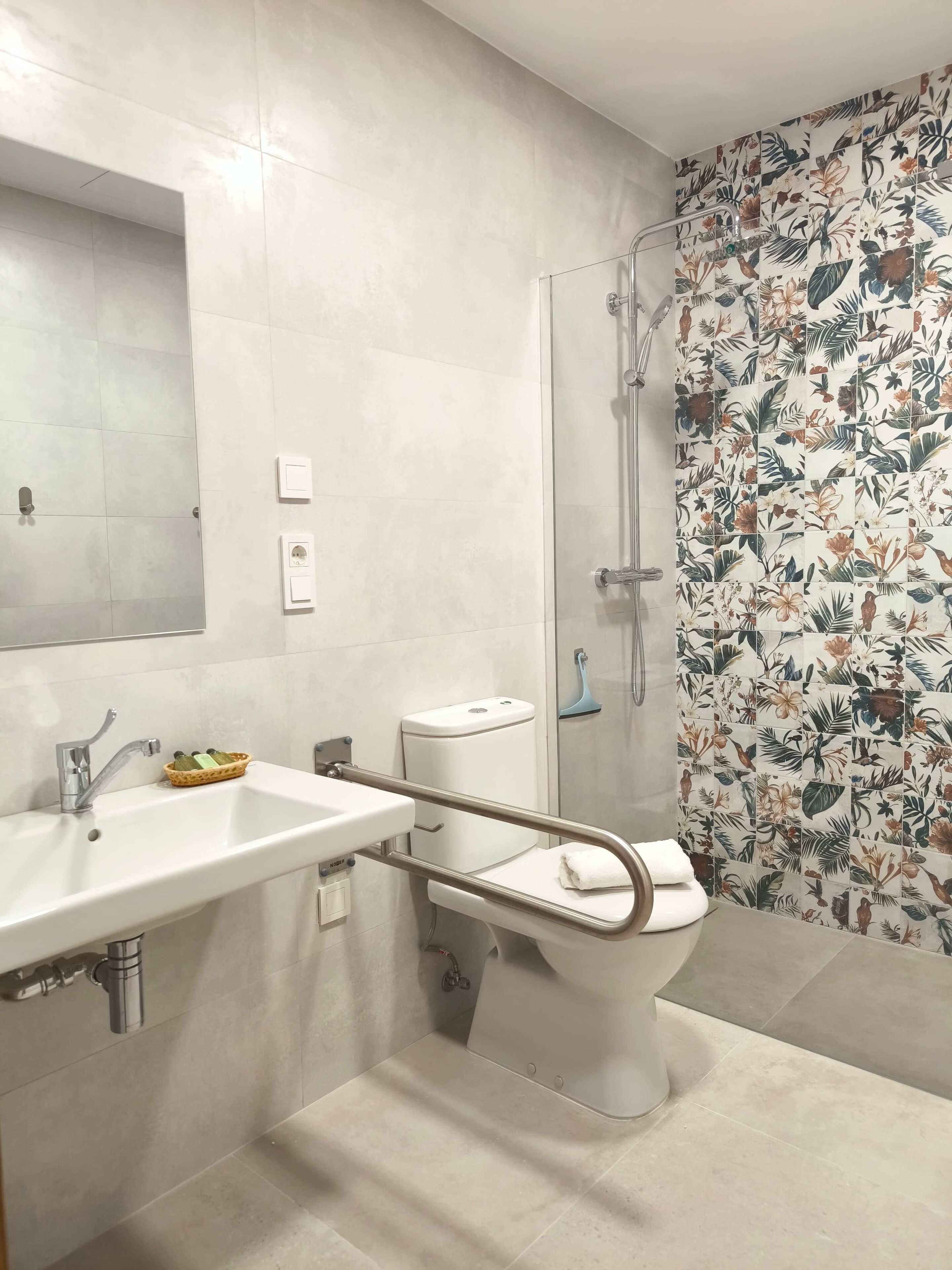 Een moderne badkamer met een wit wastafel, toilet en douche.