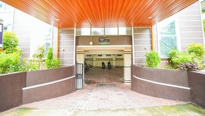 A hotel entrance with a wooden ceiling, a signboard, and a gated entrance. - Hotel Liv By Yellow Bells (Hyderabad)