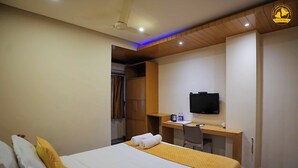 A hotel room with a bed, a desk, a chair, a television, and a wardrobe. - Hotel Liv By Yellow Bells (Hyderabad)
