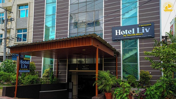 A hotel entrance with a covered waiting area, potted plants, and a sign for Hotel Liv by Yellow Bells. - Hotel Liv By Yellow Bells (Hyderabad)