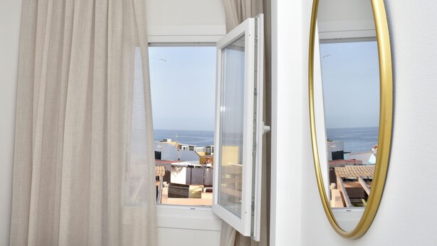 A room with a large window, a view of the sea, and a golden-framed mirror. - BENCOMO SUNSET YOUR FAMILY APARTMENT NEXT TO LORO PARK (Puerto de la Cruz)