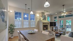 A spacious living area with a wooden dining table, white chairs, a sofa, and a ceiling fan. - 3BR Retreat near South 1st St. | Walk to SoCo (Austin)
