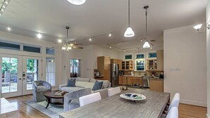 A modern kitchen with built-in appliances, a dining area with a wooden table, and a seating area with a sofa and armchairs. - 3BR Retreat near South 1st St. | Walk to SoCo (Austin)