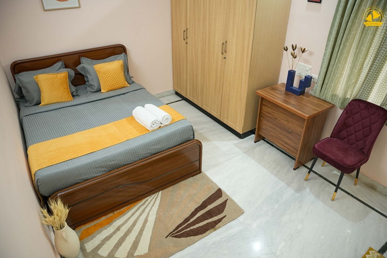 A bedroom with a bed, a wardrobe, a desk, and a chair.