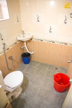 Un baño pequeño con inodoro, lavamanos y ducha.