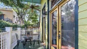 A covered patio with a table and chairs, a ceiling fan, and a view of neighboring houses.