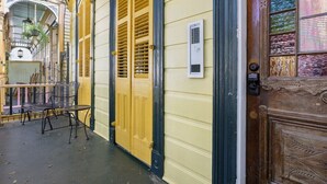 A narrow street with yellow doors and a small outdoor seating area.