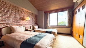 Une chambre d’hôtel avec deux lits, un mur en briques, une fenêtre avec des rideaux et une armoire.