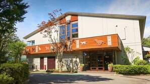 Un bâtiment moderne doté d’une façade en bois, de grandes fenêtres et d’un porche.