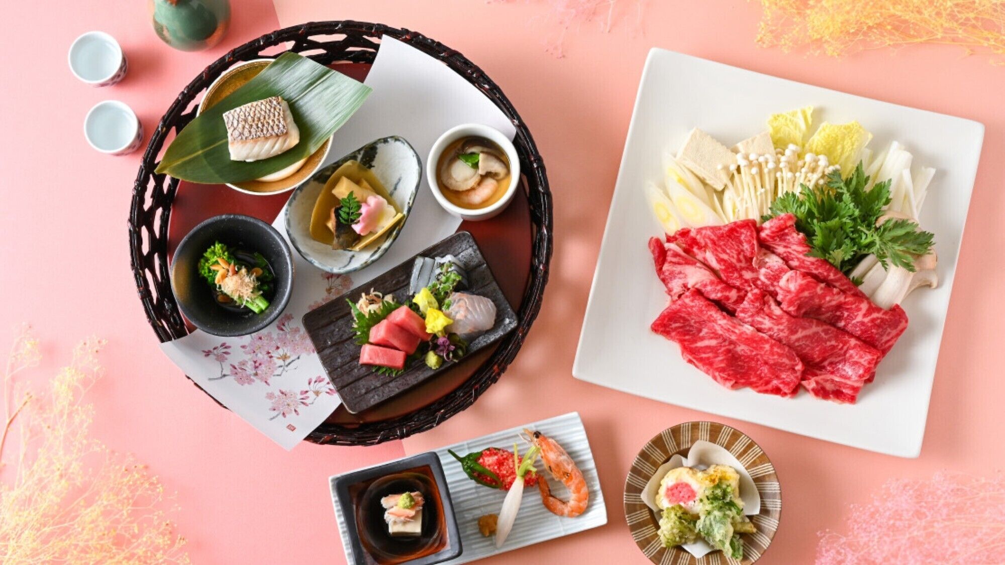 Variedad de platos japoneses, incluyendo sushi, sashimi y una selección de carnes crudas, servidos sobre una mesa rosa con una cesta tejida y cuencos pequeños.