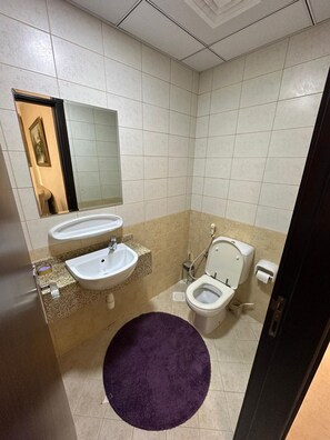 A bathroom with two sinks, a toilet, and a mirror. - Spacious 3-bedroom apartment in lovely Sharjah with all services (Sharjah)