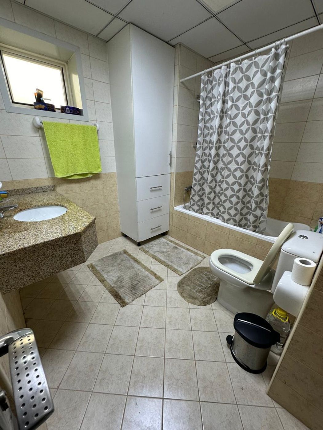 Une salle de bain équipée d’un lavabo, de toilettes, d’une douche et d’un meuble de rangement.