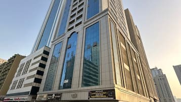Un edificio alto e moderno con facciata in vetro e un negozio a piano terra.
