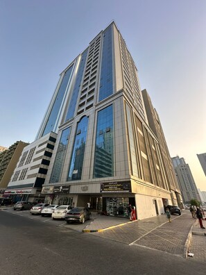 Un edificio alto y moderno con fachada de vidrio y una tienda en la planta baja.