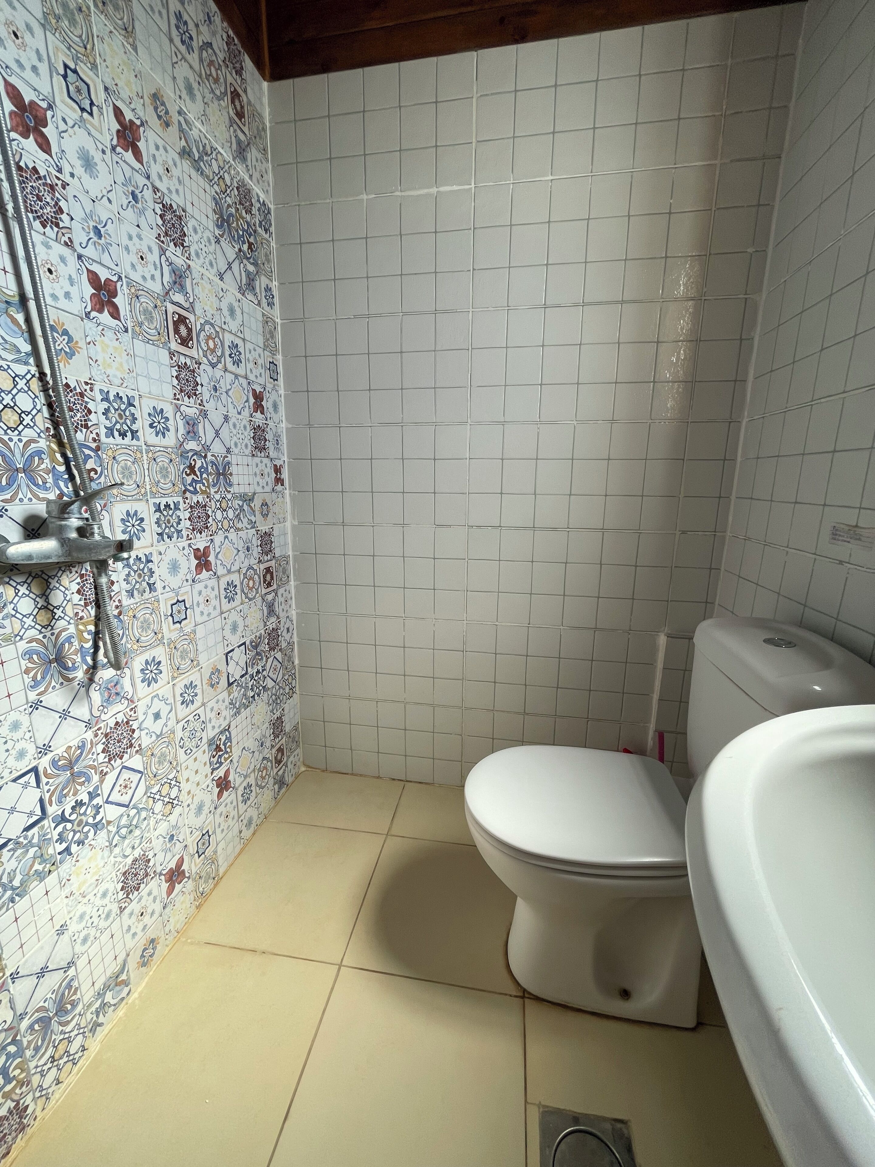 Une salle de bain comprenant des toilettes, un bidet et un espace douche.