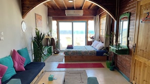 Une pièce confortable avec un lit, un canapé et un plafond en bois.
