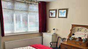A bedroom with a bed, a dresser, a desk, and a radiator. - River breeze ground floor easy access with river view. Dog friendly. Sleeps 4  (Horning)
