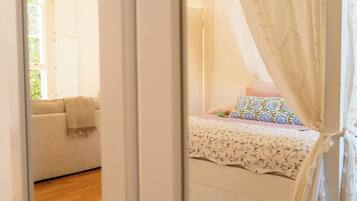 Un dormitorio con cama, sofá y ventana.