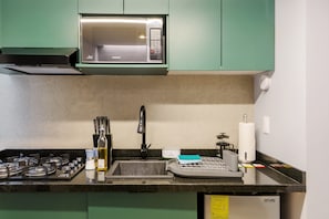 A kitchen with a microwave, stove, sink, and various utensils. - w Cozy 1BR in Polanco (Mexico City)