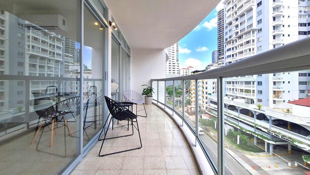 A balcony with a glass railing, a chair, and a potted plant. - w Modern 2BR In La Cresta (Panama City)