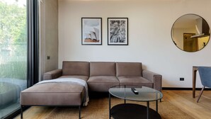 A modern living room with a brown leather sofa, a glass coffee table, and a round mirror on the wall. - w Fabulous 1BR With Elegant Balcony in Roma Nte (Mexico City)