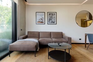 A modern living room with a brown sofa, a glass coffee table, and two framed pictures on the wall. - w Fabulous 1BR With Elegant Balcony in Roma Nte (Mexico City)