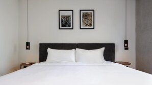 A large bed with white linens, two framed pictures on the wall, and two pendant lights. - w Fabulous 1BR With Elegant Balcony in Roma Nte (Mexico City)