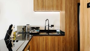 A modern kitchen with wooden cabinets, a black countertop, and a stainless steel sink. - w Fabulous 1BR With Elegant Balcony in Roma Nte (Mexico City)