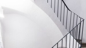 Una escalera de caracol con barandilla de metal negro que conduce a una plataforma.