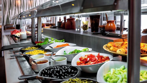 A buffet with various food items and serving utensils. - Rénéa Hotel (Sétif)