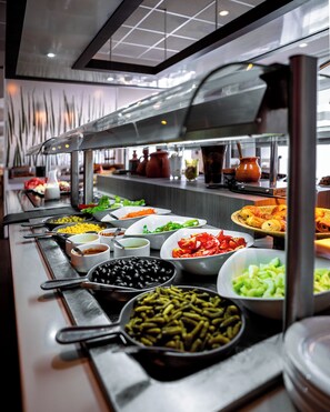 A buffet with various food items and serving utensils. - Rénéa Hotel (Sétif)