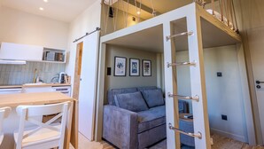 A compact, modern room with a loft bed, a sofa, and a dining area. - (034) Le Cocon Méditerranéen (Antibes)